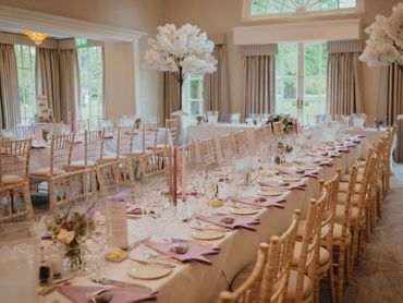 Wedding table styling with blossom trees and lilac napkins & floral arrangements