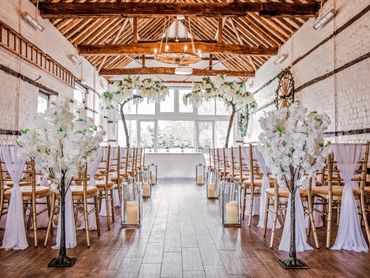 Wedding ceremony styling at Lillibrooke Manor with Wisteria & blossom trees and silver lanterns