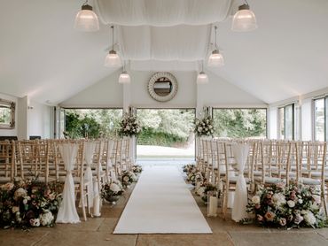 Wedding ceremony styling at Wasing Park in Berkshire with chair sashes and floral arrangements