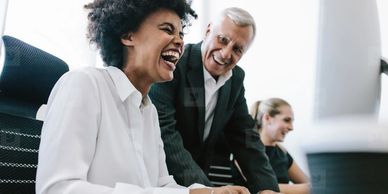 Older consultant laughing with younger colleague
