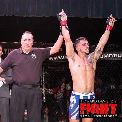 Coach Chris with his arm raised after an MMA fight victory