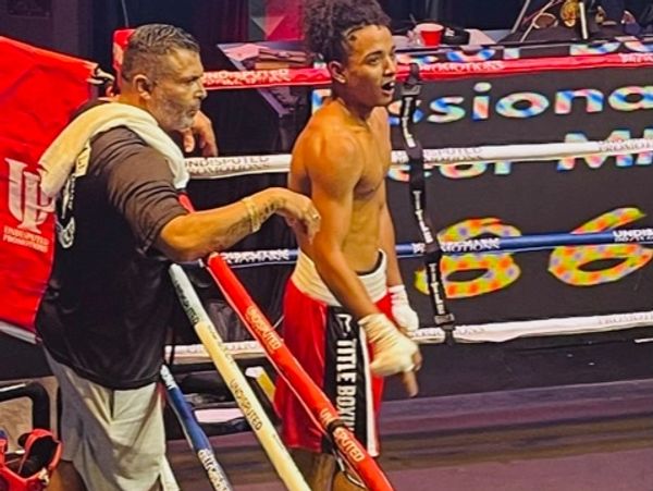Coach Rick in the boxing ring coaching a young fighter between rounds