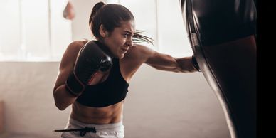 Adult woman in a cardio boxing workout, focused on fitness and form.