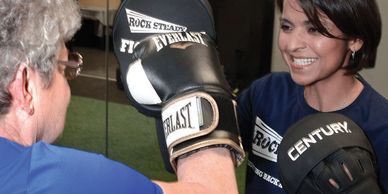 Participant with Parkinson’s training with Rock Steady Boxing gloves in Palm Coast.