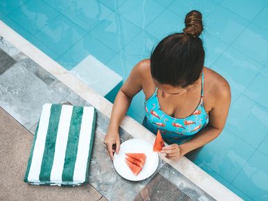 Lady eating by the swimming pool