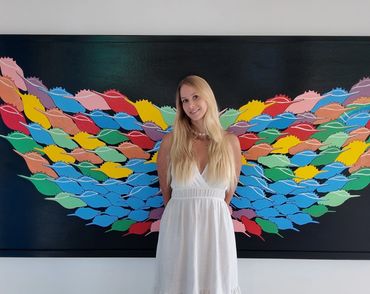 A woman with wings painting behind her.