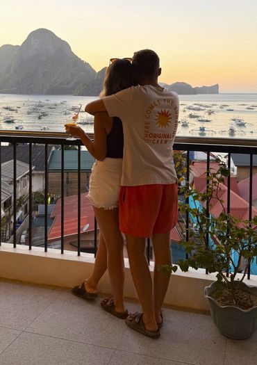 A couple watching the view of the bay and the island during sunset on the rooftop view deck.