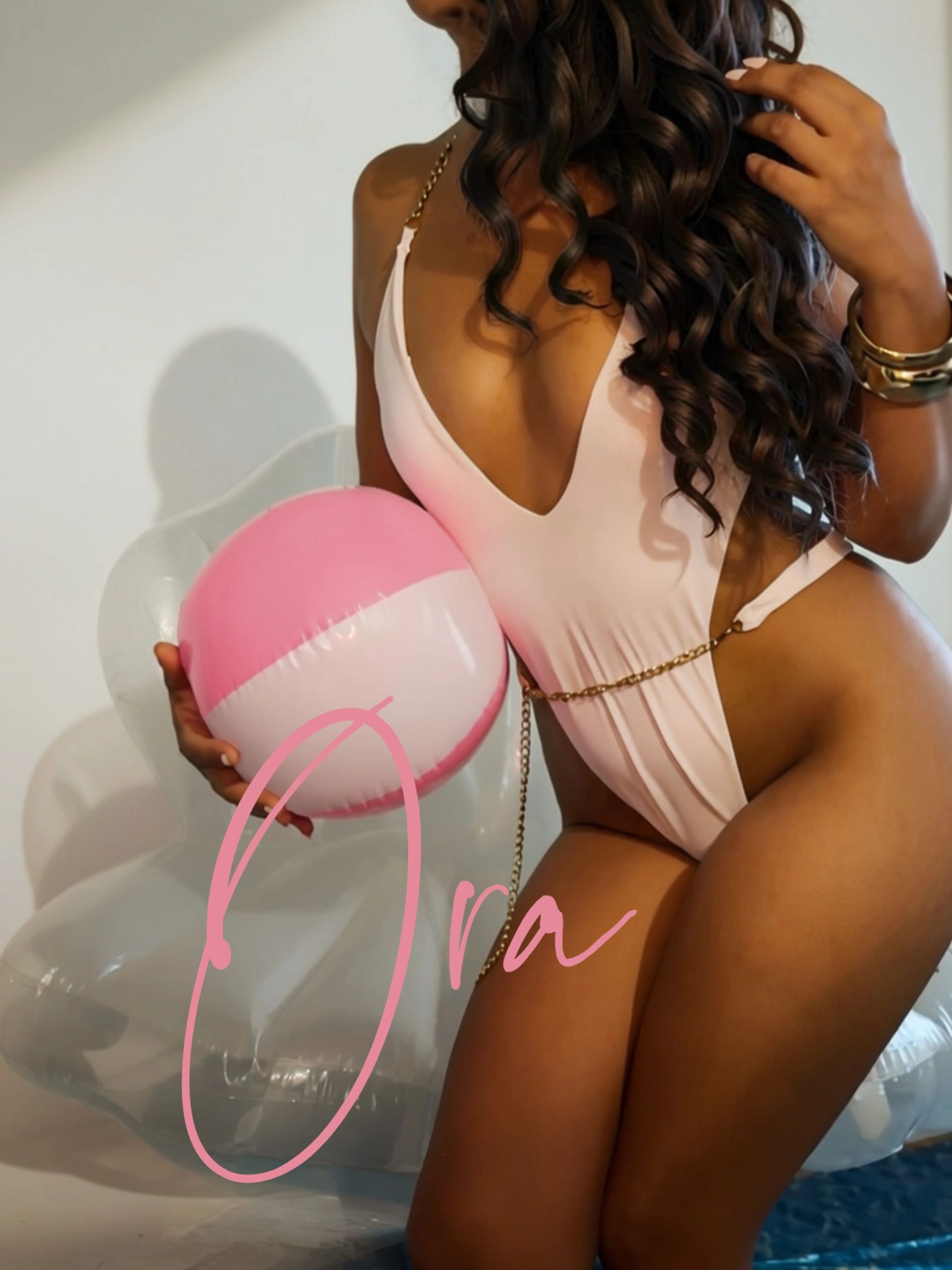 Femme en maillot rose avec ballon de plage.
