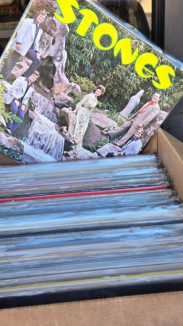 Vinyl records in a box with a vintage Stones album cover on top.