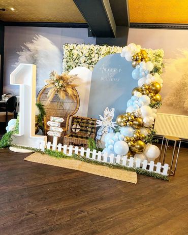 Elegant setup for Aarav's 1st birthday with balloons and floral decor.