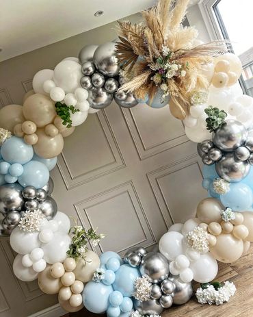 Elegant balloon arch with neutral tones and floral accents.