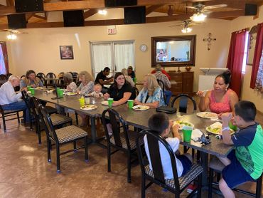 Diverse group sharing a meal in a cozy dining room with wooden beams.