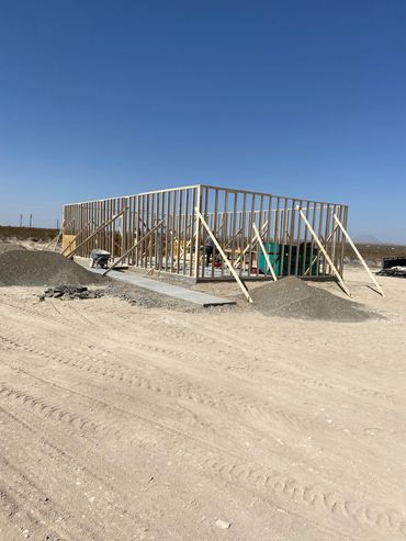 Wooden frame of a building under construction in a desert area.
