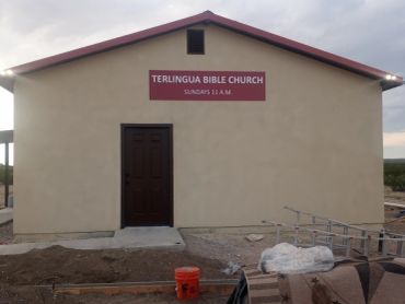 Simple beige church building with a sign for Terlingua Bible Church.