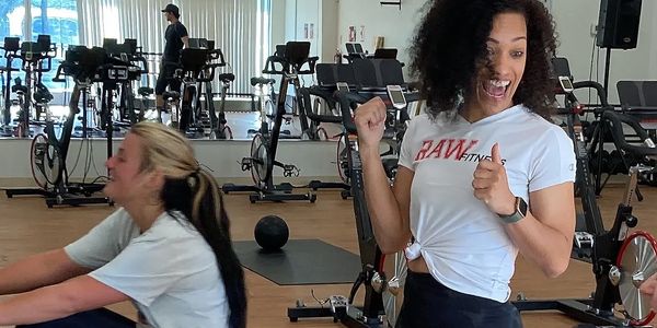 Trainer guiding client with weights — Raw Fitness weight loss coaching for sustainable results.