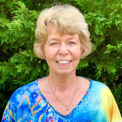 Mrs. Hartshorn is pictured smiling. She has sandy blonde hair and is wearing a blue shirt.