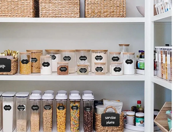 Organized pantry shelves with labeled containers and baskets.