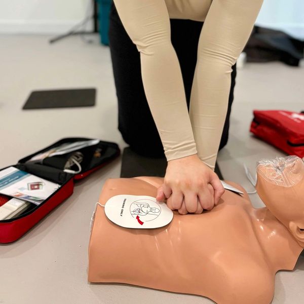 Person performing CPR on a training manikin.
