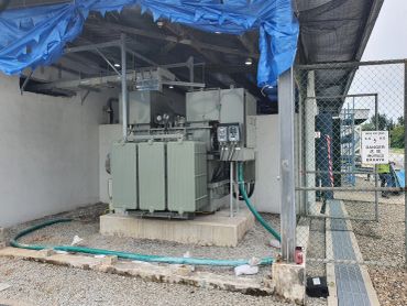Industrial electrical transformer with high voltage warning sign.
