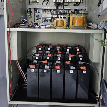 Electrical control panel with labeled batteries and components.