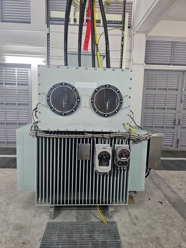 Industrial solar PV transformer with gauges and cables in a facility.