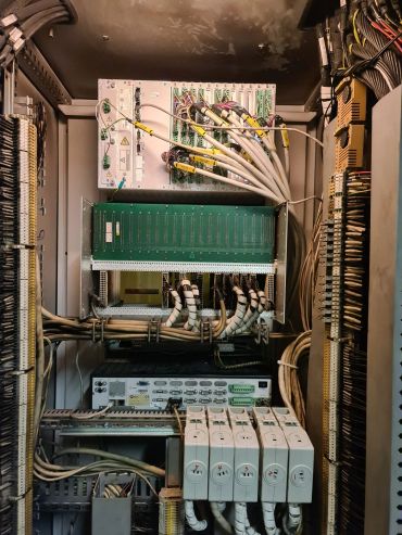 Inside a complex electrical control panel with organized cables and labeled components.