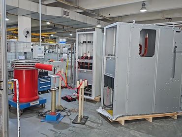 High-voltage electrical testing equipment in a factory setting.