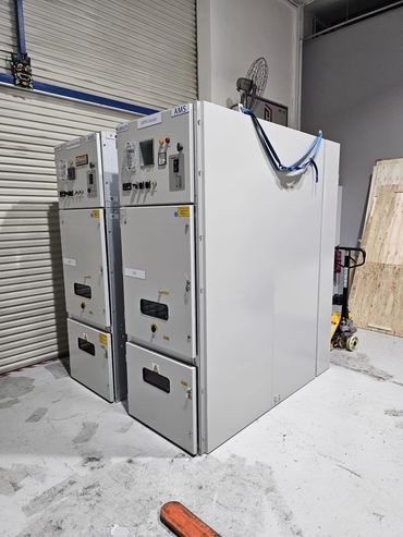 Industrial electrical control panels in a warehouse with a pallet jack nearby.