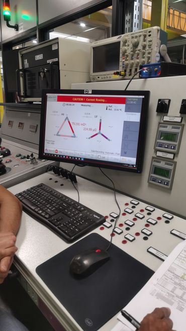 Electrical testing equipment with a computer interface in an industrial setting.