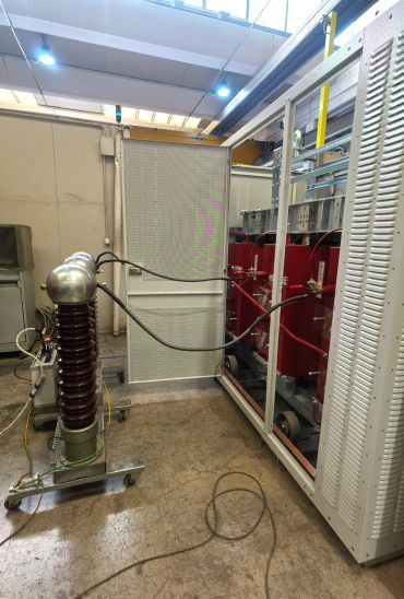 High-voltage electrical testing setup inside an industrial facility.