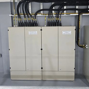 Electrical marshalling panels with organized black cables and yellow labels.