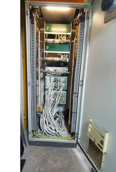 Open server rack with numerous connected cables and electronic components.