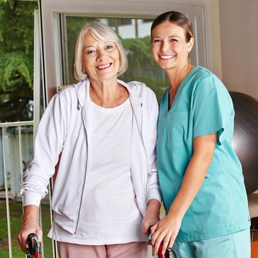 Happy senior woman with walker and nurse in a physiotherapy
