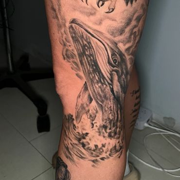 Large black and grey whale wildlife tattoo on leg