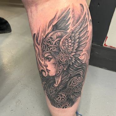 Black and grey Viking warrior woman tattoo with detailed helmet and wings