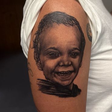 Realistic black and grey child portrait tattoo by Indianapolis tattoo artist Eric