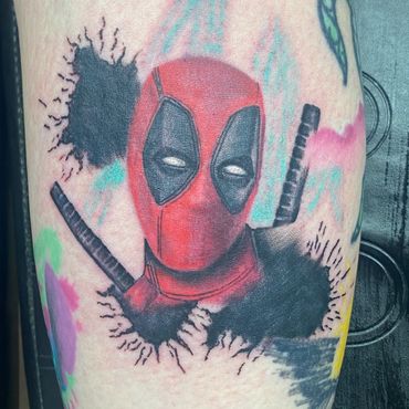 Color Deadpool tattoo with red, black and watercolor-style background