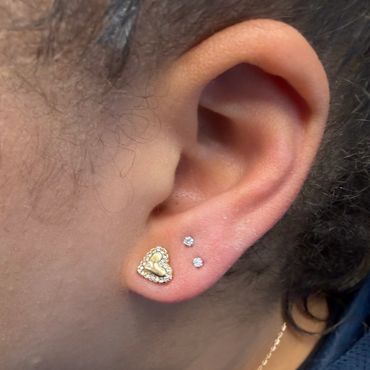 Stacked ear lobe piercing with gold heart jewelry