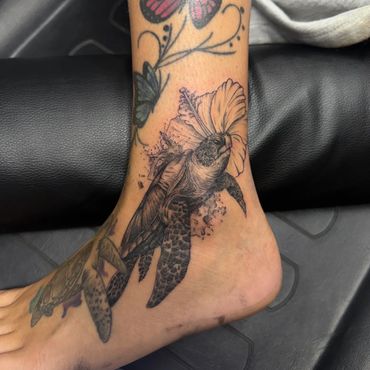 Black and grey sea turtle and hibiscus ankle tattoo