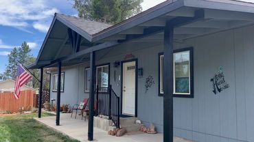 A happy customer wanted a front porch added so that she could end her day enjoying the sunsets.
