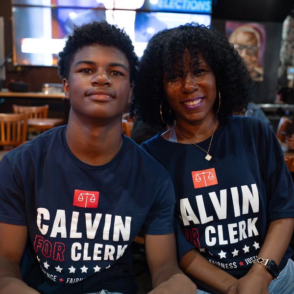 Two people wearing matching Calvin for Clerk shirts.