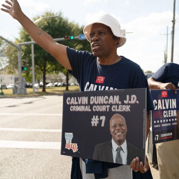 Man holding a campaign sign for Calvin Duncan, criminal court clerk.
