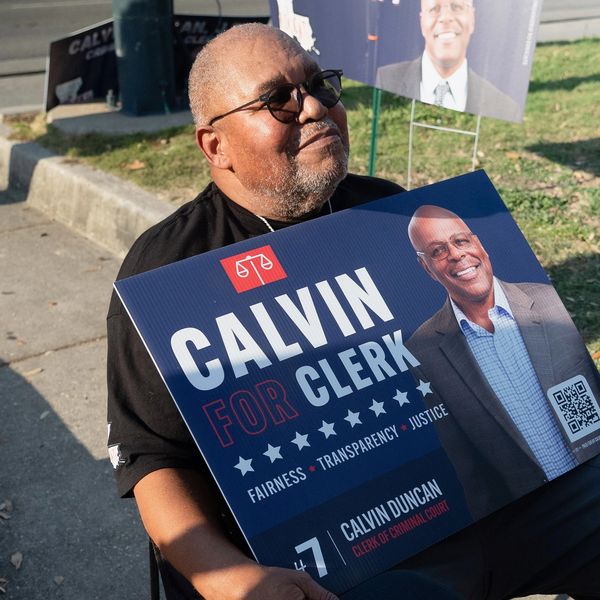 Man holding a campaign sign for Calvin Duncan for Clerk.