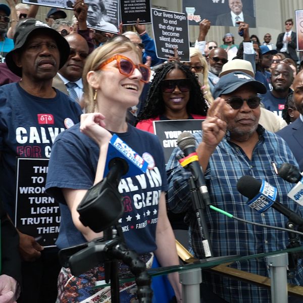 Group at a rally with speakers and signs.