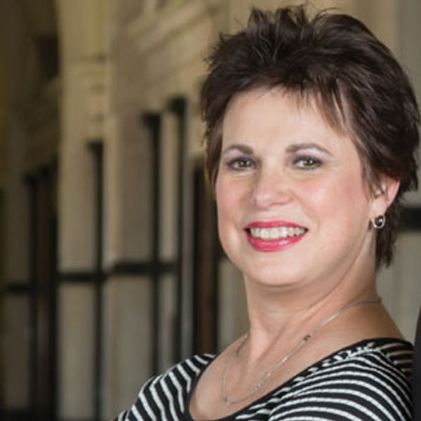 Smiling woman with short brown hair in striped top.