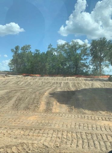 Cleared and graded property with visible equipment tracks.