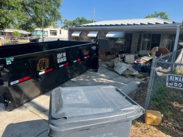 Roll-off dumpster positioned at a residential property for debris removal.