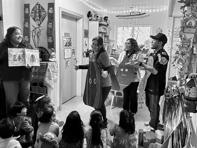 Teachers in costumes engaging young children in a lively classroom story session.