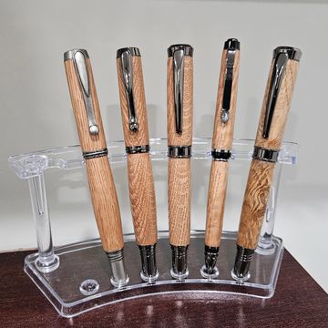 Five wooden pens with metal accents on a clear stand.
