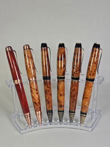 Six elegant wooden pens in a clear stand.